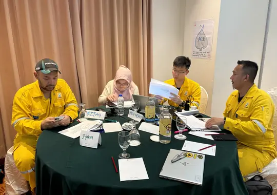 A team in coveralls working at a round table
