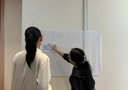 Two participants writing on a flipchart