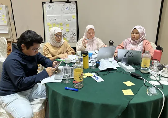 A team working with laptops and sticky notes