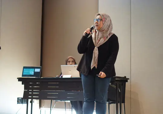 A participant presenting to the room with a microphone