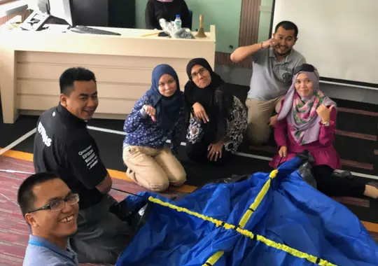 A team smiling on the floor after an exercise