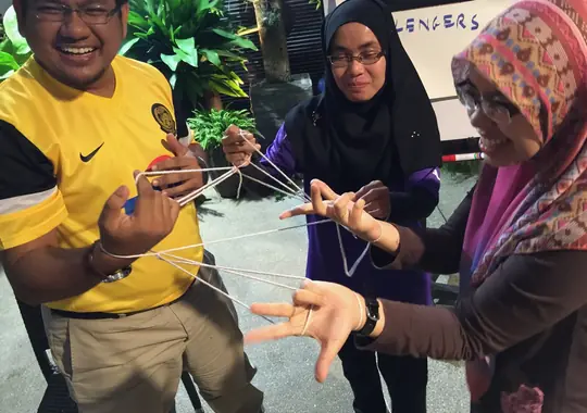 Participants untangling a rope challenge together